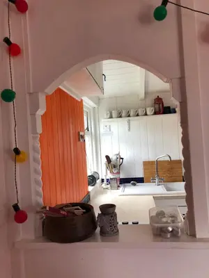 a kitchen with an archway in a doll house at Hippy beach shack in Hayle