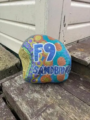 a birthday cake sitting on top of a bench at Hippy beach shack in Hayle