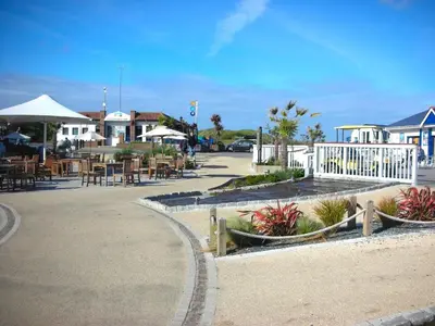 a parking lot with tables and chairs and a restaurant at Chalet 151, Perran Sands in Perranporth