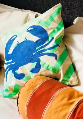 a pillow with a blue crab on it sitting on a bed at The Gallery in Port Isaac