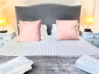 a bedroom with a bed with pink pillows at The Gallery in Port Isaac