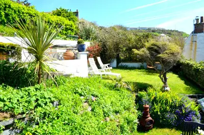 a garden with a bench and some plants and flowers at The Gallery in Port Isaac