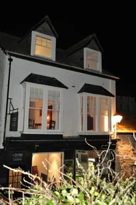 a white house with windows at night at The Gallery in Port Isaac