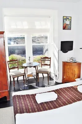 a living room with two chairs and a table and a television at The Gallery in Port Isaac