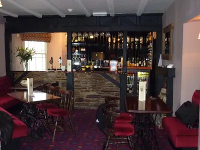 a restaurant with tables and chairs and a bar at Royal Oak Inn in Lostwithiel