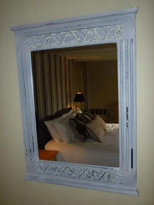 a mirror hanging on a wall next to a bed at Royal Oak Inn in Lostwithiel