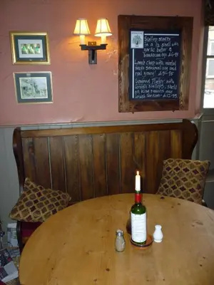 a bottle of wine sitting on a table in a restaurant at Royal Oak Inn in Lostwithiel