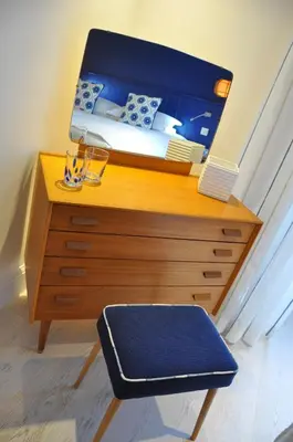 a bedroom with a bed and a dresser with a mirror at Trevose Harbour House in St Ives