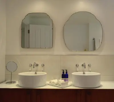 two sinks in a bathroom with two mirrors at Trevose Harbour House in St Ives