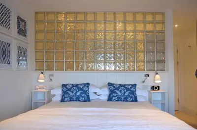 a bedroom with a bed with two blue pillows at Trevose Harbour House in St Ives