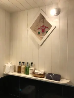 a shelf in a bathroom with toiletries on it at Samphire in Padstow