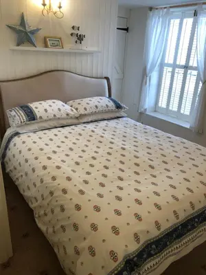 a bed with a comforter on it in a bedroom at Samphire in Padstow