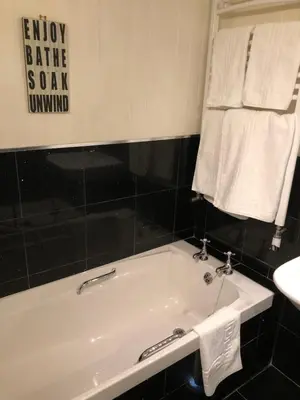 a white bath tub in a bathroom with towels at Samphire in Padstow