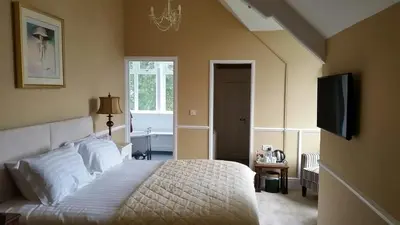 a bedroom with a bed and a flat screen tv at Pencubitt House in Liskeard