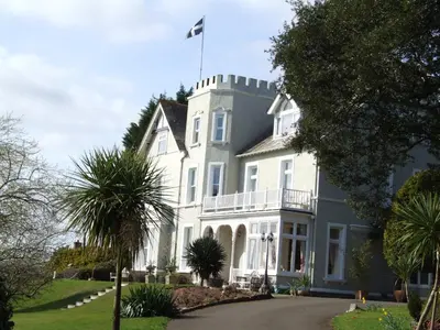 a large white house with a flag on top at Pencubitt House in Liskeard