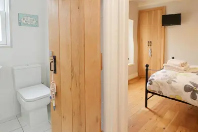 a bathroom with a toilet and a bed at TOWN CENTRE contemporary cottage in Padstow