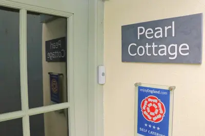 a sign on the side of a door with a pearl cottage at TOWN CENTRE contemporary cottage in Padstow