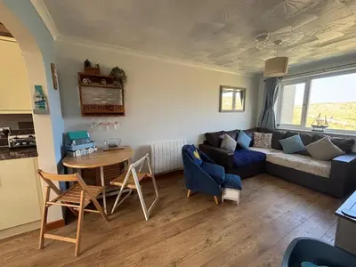a living room with a couch and a table at Dunes View - Atlantic Bay in Perranporth