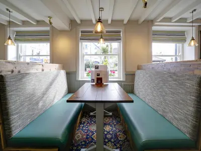 a room with two booths with a table and benches at The Swan Hotel in Wadebridge