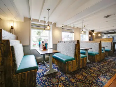a restaurant with wooden chairs and tables and a table at The Swan Hotel in Wadebridge