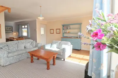 a living room with a couch and a coffee table at BY THE BEACH Harlyn Bay in St Merryn