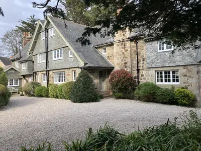 a large stone house with a gravel driveway at Penquite Holiday Accommodation in Uny Lelant