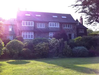 a large red brick house with white windows at Penquite Holiday Accommodation in Uny Lelant