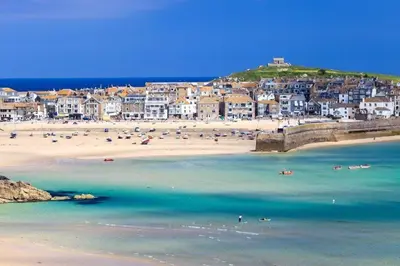 a beach with a group of people in the water at Penquite Holiday Accommodation in Uny Lelant