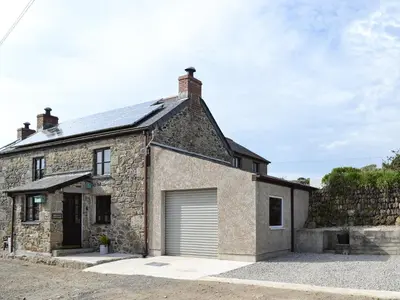 an old stone house with a garage at Bruce's Cottage in Saint Erth