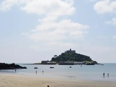an island in the water with people on a beach at Bruce's Cottage in Saint Erth