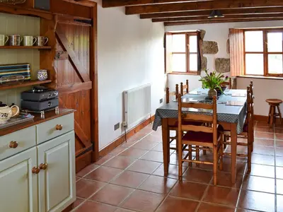 a kitchen with a table and chairs in a room at Bruce's Cottage in Saint Erth