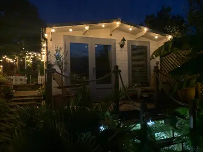 a white house with lights on it at night at Stargazy Garden in Hayle