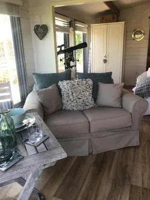 a living room with a couch and a table at Stargazy Garden in Hayle