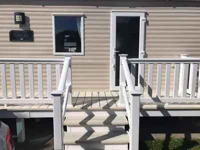 a porch of a house with a white railing at Luxury Holiday Caravan Home in Newquay