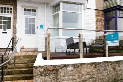 a porch of a house with a bench on it at Ocean House in St Ives