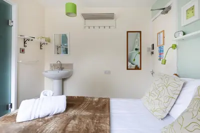 a bathroom with a bed and a sink in a room at Ocean House in St Ives