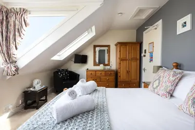 a bedroom with a bed with towels on it at Ocean House in St Ives