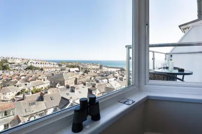 a window with bottles sitting on a ledge at Ocean House in St Ives