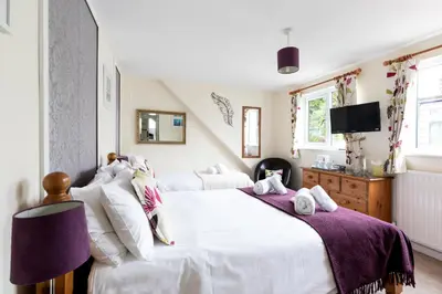a bedroom with two white beds and a tv at Ocean House in St Ives