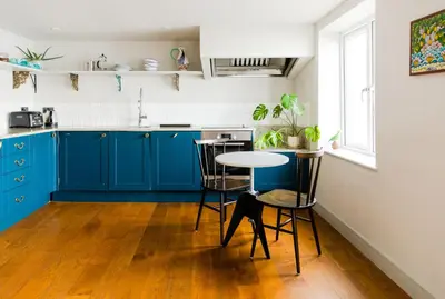 a kitchen with blue cabinets and a table at Star & Garter in Falmouth