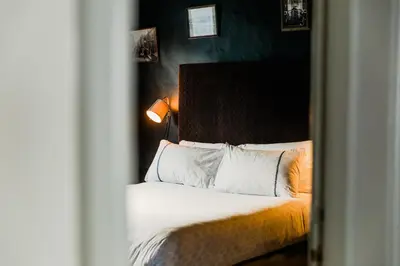 a bedroom with a bed with white sheets and pillows at Star & Garter in Falmouth