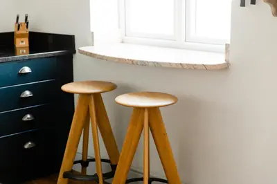 two wooden stools in a kitchen next to a counter at Star & Garter in Falmouth