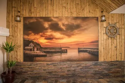 a painting of a pier with a sunset at Deluxe Rustic Charlestown Themed Apartment in St Austell