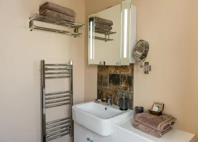 a bathroom with a sink and a mirror at Deluxe Rustic Charlestown Themed Apartment in St Austell