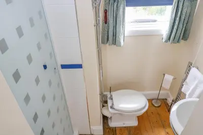 a small bathroom with a toilet and a window at 1 Dormer Villas in Porthscatho