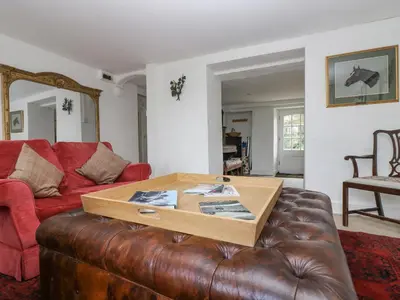 a living room with a brown leather couch and a table at Little Chycoose in Truro