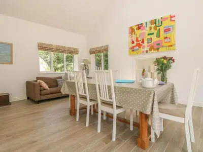 a dining room and living room with a table and chairs at Little Chycoose in Truro