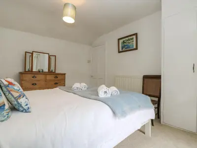 a bedroom with a white bed with towels on it at Little Chycoose in Truro