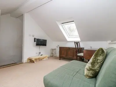 a living room with a couch and a television at Little Chycoose in Truro