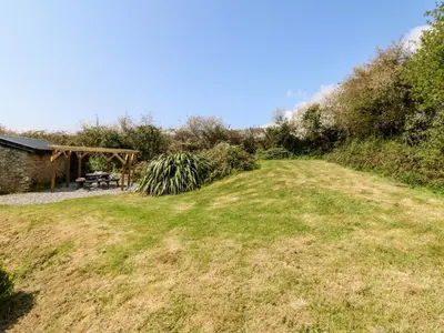 a grassy hill with a picnic table in the background at Leghorn in St Austell